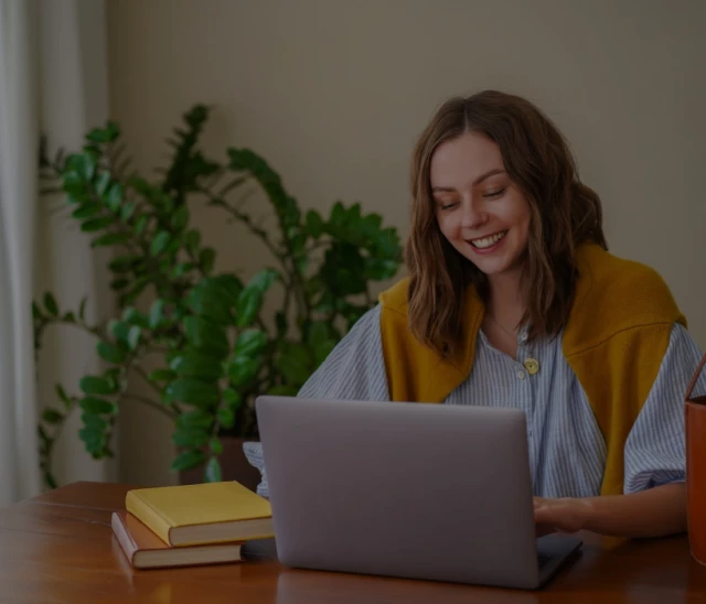 a women looking at her laptop and smiling